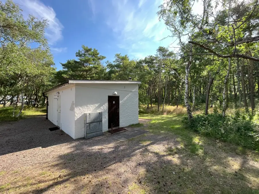 Ett vitt servicehus bland tallar