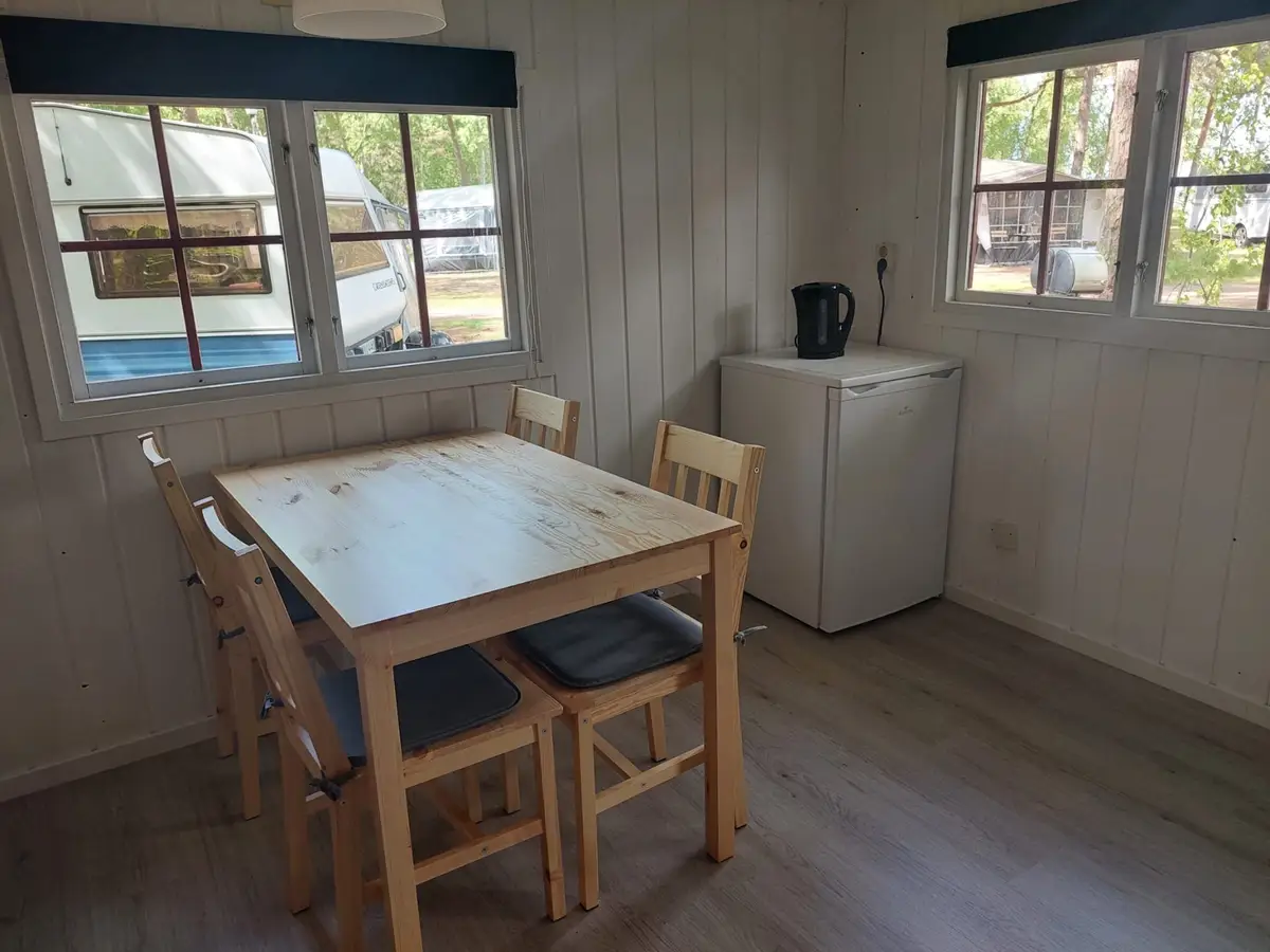 Bord, stolar och kylskåp i stugan